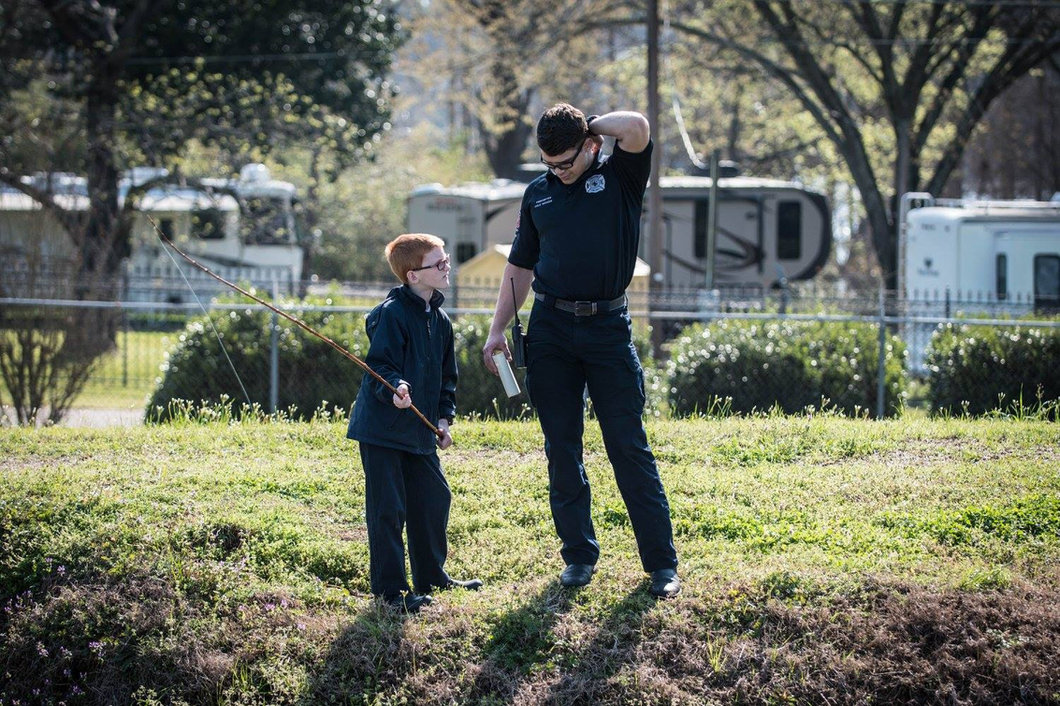 A volunteer helping a child learn to fish